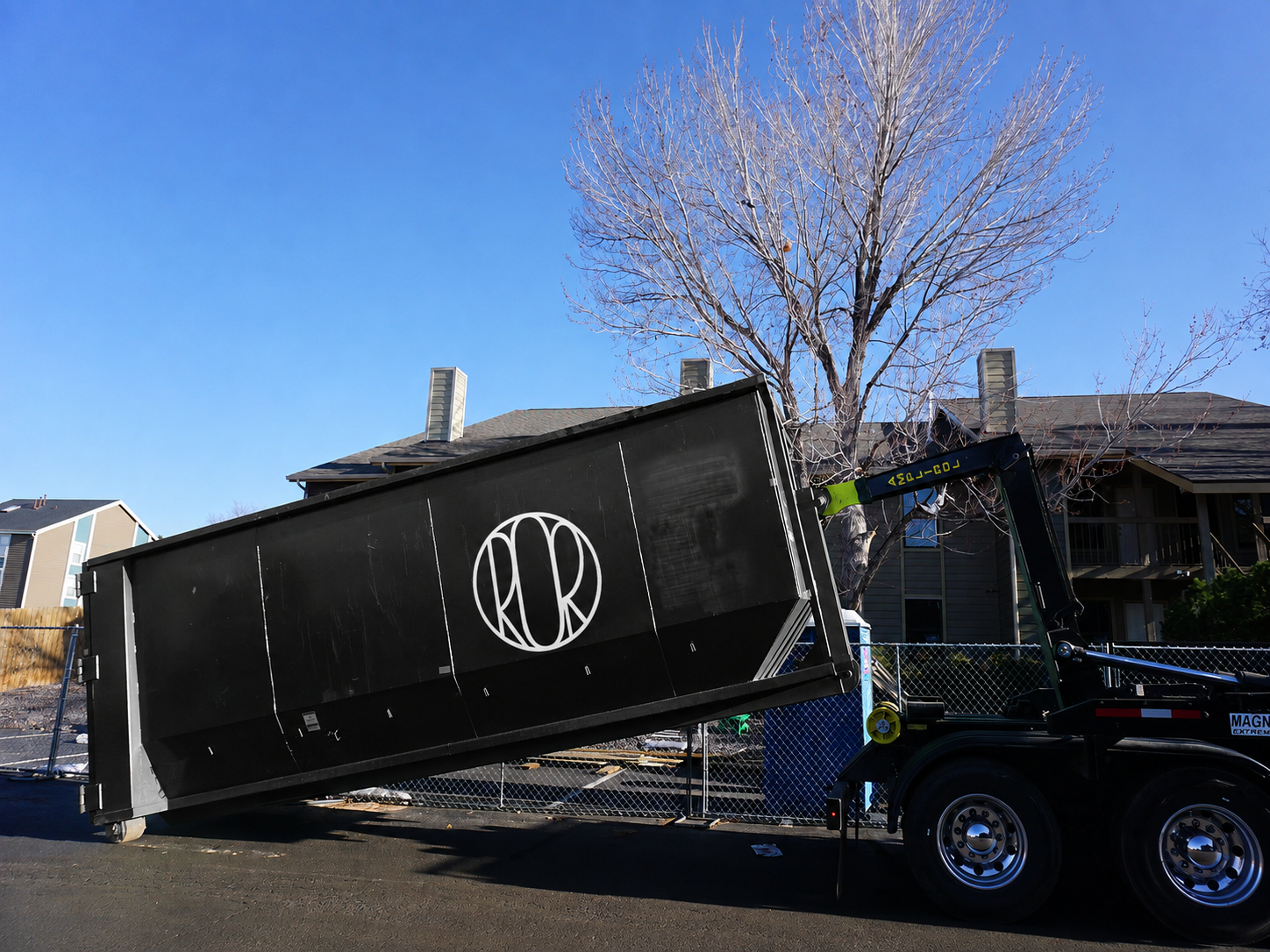 Workers loading a Roll-Off Dumpster at a Henderson - CO property during a large cleanup project