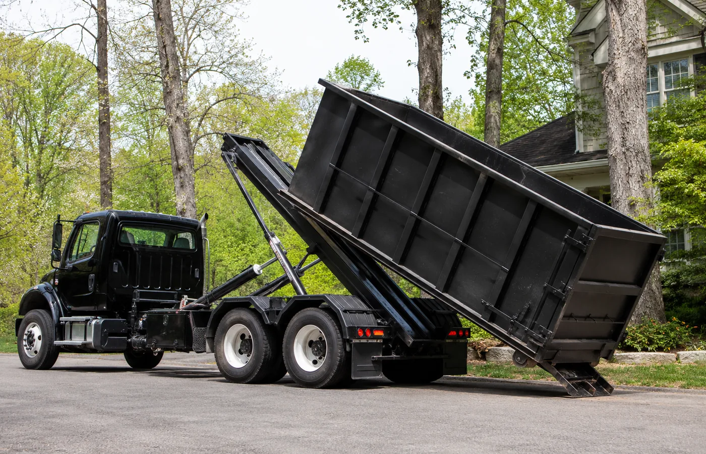 Crew loading a Roll-Off Dumpster outside a Highlands Ranch - CO house during interior renovation work, Crew loads a Roll-Off Dumpster beside a Columbine - CO home during a controlled remodel cleanup