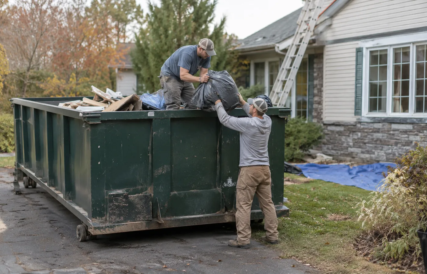 Homeowner loading residential dumpster rental debris outside a Northglenn - CO property during a cleanup, Homeowner loading residential dumpster rental debris outside a Louisville - CO house during a room renovation